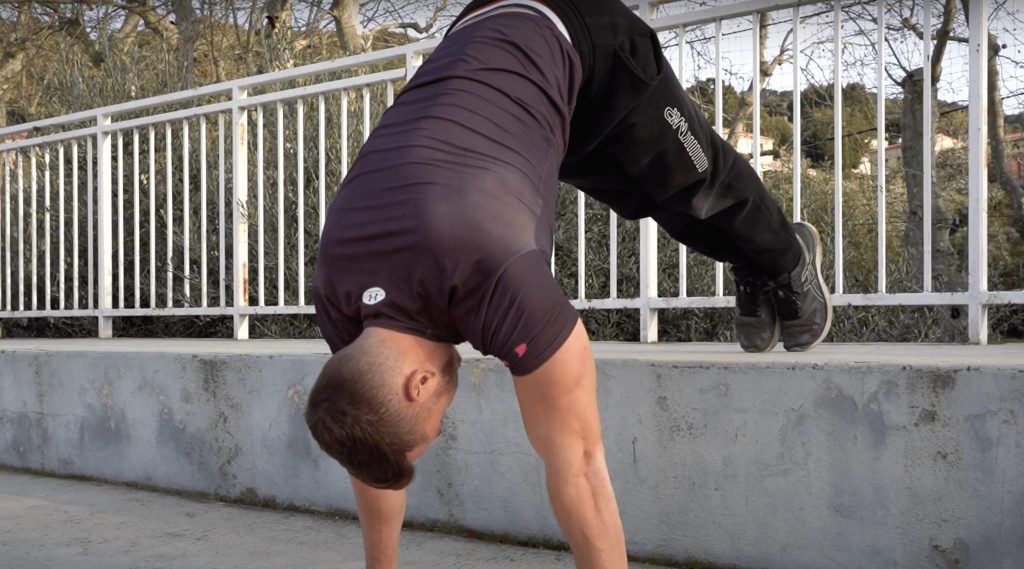 Homme faisant des pompes pike pieds surélevés